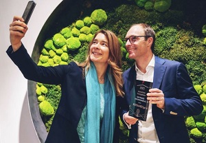 Ingrid Krawarik, Mitarbeiterin beim Börsianer, übergibt Georg von Pföstl, Vorstand der fair-finance Vorsorgekasse, die Auszeichnung als innovativste Vorsorgekasse 2023, was mit einem Selfie festgehalten wird